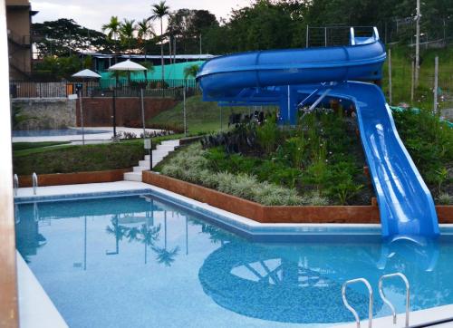 a blue water slide in a swimming pool at ApartaSol Reserva de la Colina in La Tebaida