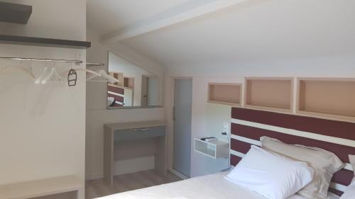 a bedroom with a bed with a brown and white headboard at Ola Kala Apartments and Rooms in Vlikhon
