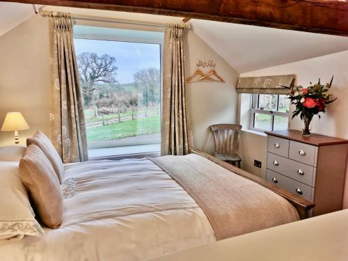 a bedroom with a bed and a window at The Stables in Monmouth