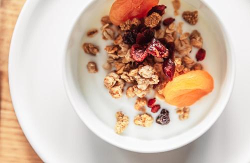 a bowl of granola with dried fruit and orange slices at Burgi's - Adults only in Lech am Arlberg