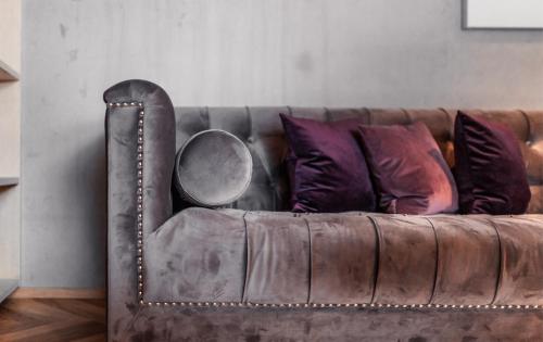 a brown leather couch with pillows and a mirror at Burgi's - Adults only in Lech am Arlberg
