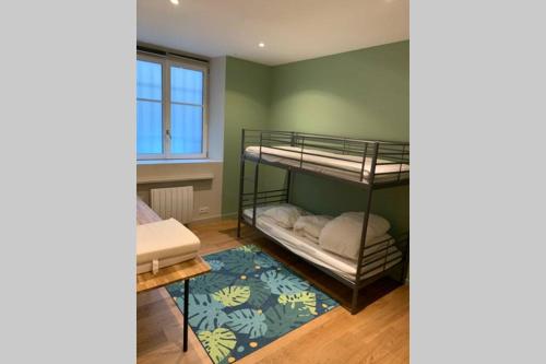 Zimmer mit 2 Etagenbetten und einem Teppich in der Unterkunft La Fabrique à Souvenirs in Saint-Malo
