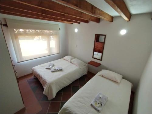 een slaapkamer met 2 bedden en een raam bij Villa Fortuna in Villa de Leyva