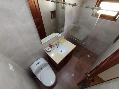 ein Badezimmer mit einem WC, einem Waschbecken und einem Spiegel in der Unterkunft Villa Fortuna in Villa de Leyva