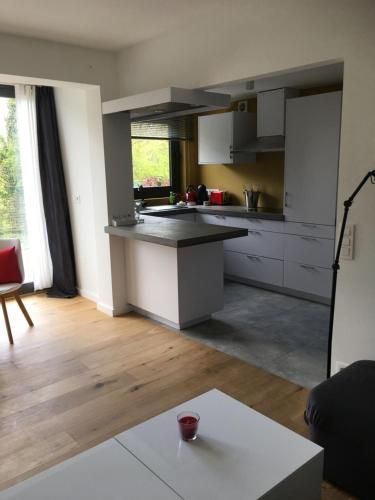 cocina con armarios blancos y encimera en Appartement met groot terras, en Mortsel