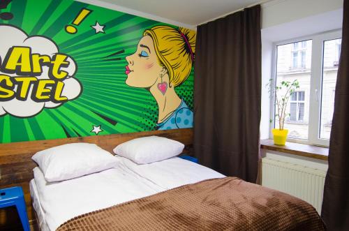 a bedroom with a bed with a painting on the wall at Pop Art Hostel Rynok Sq in Lviv