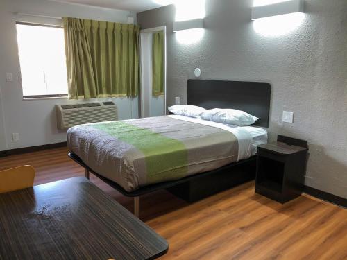 a bedroom with a bed and a table in it at Studio 6 Wichita, KS - Airport in Wichita