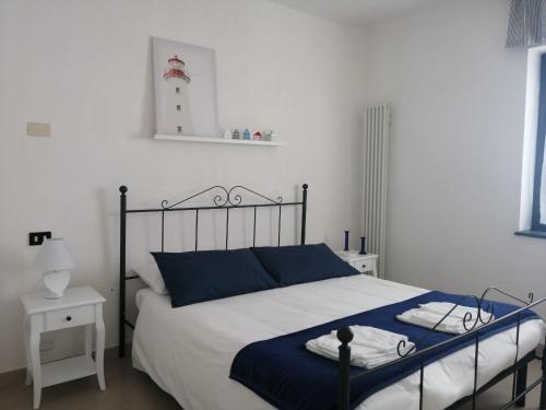 a bedroom with a bed with blue and white sheets at Lucky House in La Spezia