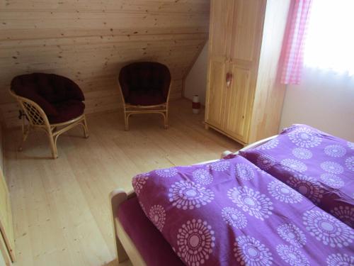 a bedroom with a bed and two chairs at Rekreační dům v Brdech Pod Svatou Annou in Ohrazenice