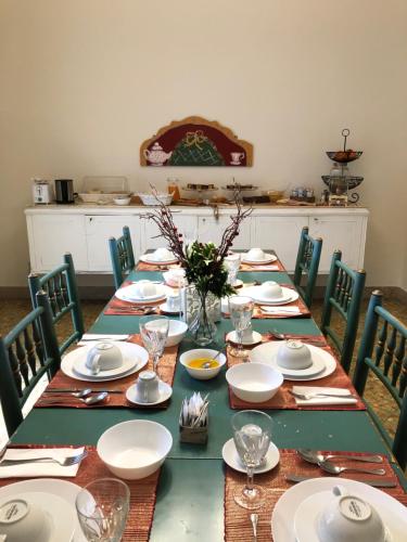 una mesa larga con platos y platos. en Casa Jolanda B&B, en Palermo