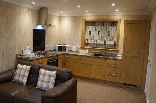 a living room with a couch and a kitchen at Myrtle Bank Hotel in Gairloch