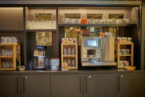 a counter with a coffee shop with a microwave at THOMSN Central Hotel & Appartements in Saalbach Hinterglemm