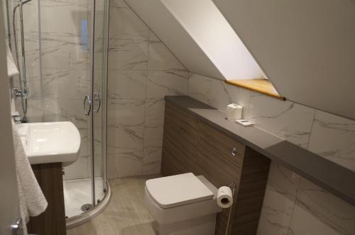 a bathroom with a shower and a toilet and a sink at Myrtle Bank Hotel in Gairloch
