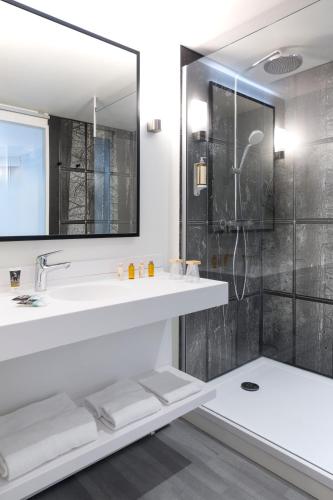 a bathroom with a sink and a shower at Mercure Aix-les-Bains Domaine de Marlioz Hôtel & Spa in Aix-les-Bains