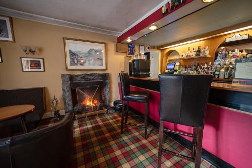 a bar in a pub with a fireplace at The Rowan Tree Country Hotel in Aviemore