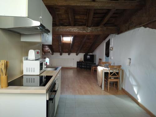a kitchen and dining room with a table and chairs at espai Abadia La Trilla in Argentera