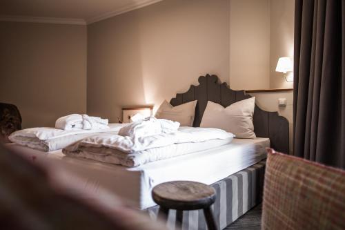 two twin beds in a hotel room with a stool at THOMSN Central Hotel & Appartements in Saalbach Hinterglemm