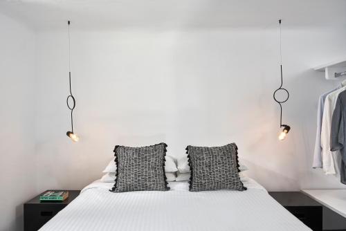 a bedroom with a bed with two black and white pillows at Almyra Guest Houses in Paraga