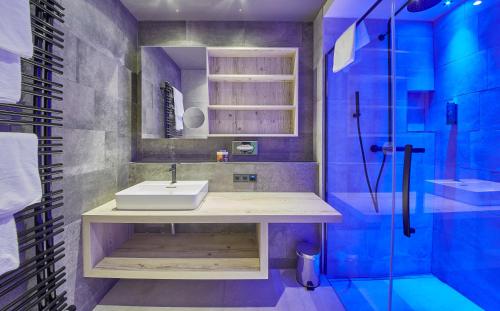 a bathroom with a sink and a shower at THOMSN Central Hotel & Appartements in Saalbach Hinterglemm