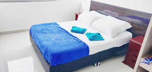 a bed with two blue pillows on top of it at Condominio peñazul la morada lo mejor in Girardot