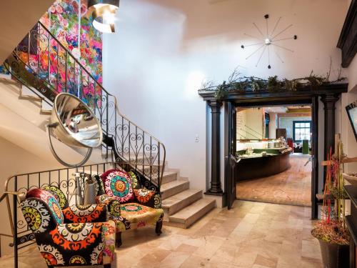 a room with a staircase with a chair and a mirror at Raffl's Tyrol Hotel in Sankt Anton am Arlberg