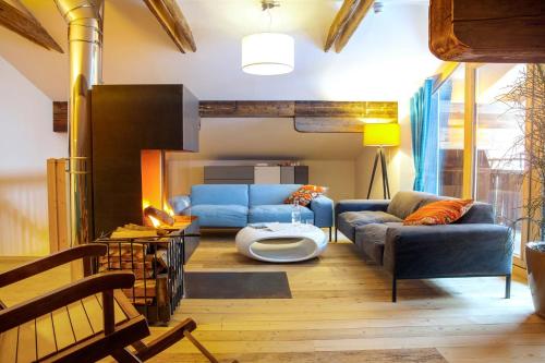 a living room with a blue couch and a table at Raffl's Tyrol Hotel in Sankt Anton am Arlberg