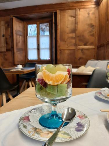 a glass of fruit on a plate on a table at Casa Pasini-Foresteria in Piuro