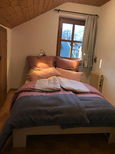 a large bed in a room with a window at Haus am Römerbad in Bad Kleinkirchheim