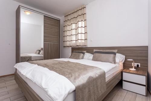 a bedroom with a large bed and a bathroom at Apartments Crnekovic Tomislava 8 in Baška