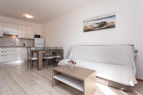 a room with a bed and a table and a kitchen at Apartments Crnekovic Tomislava 8 in Baška