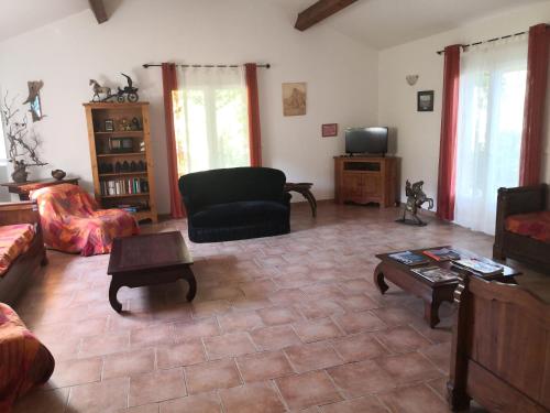 ein Wohnzimmer mit einem Sofa und einem TV in der Unterkunft l'Ogliastru in Ucciani