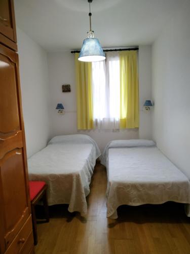 dwa łóżka w pokoju z oknem w obiekcie Coma de Alba Benasque w mieście Benasque