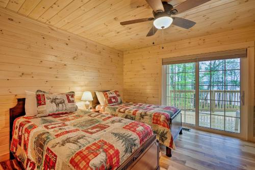1 dormitorio con 2 camas y ventilador de techo en Waterfront Davis Pond Cabin with Dock and Kayaks!, en Holden