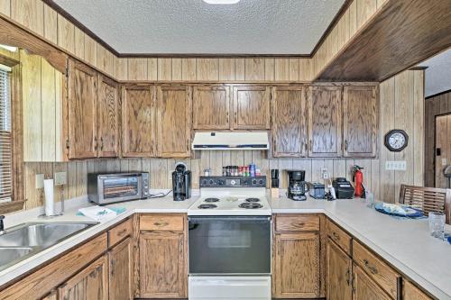 a kitchen with wooden cabinets and a stove top oven at Pet-Friendly Second Row House Steps to Beach! in Holden Beach