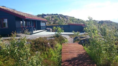 a wooden pathway leading to a house with a mountain at Offersøy Feriesenter in Offersøy