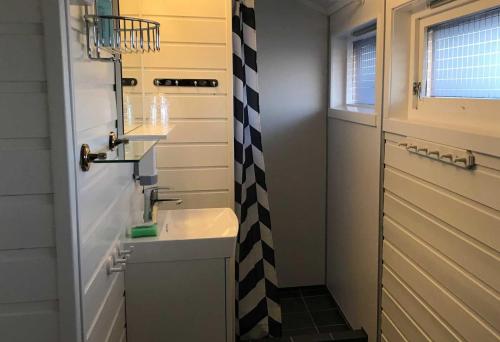 a bathroom with a black and white checkered shower curtain at Offersøy Feriesenter in Offersøy