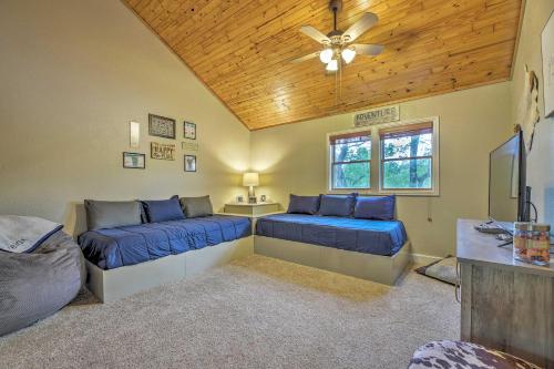 a bedroom with two beds and a ceiling fan at Updated Cabin on White River by Boat Landing! in Calico Rock