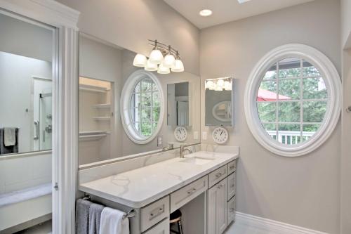 a bathroom with a sink and two windows at Contemporary Tacoma Cottage with Deck and Pond! in Tacoma