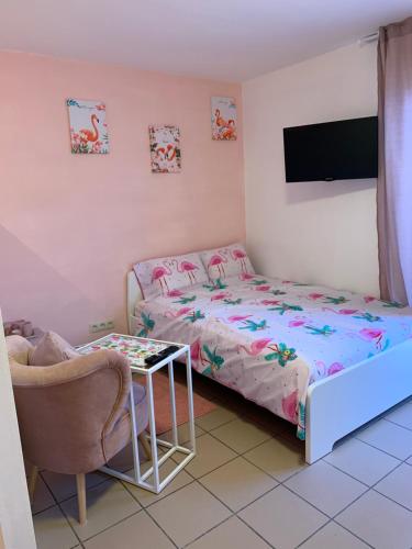 a bedroom with a bed and a tv and a table at Carpe Diem in Jumet