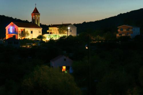 una chiesa con una torre dell'orologio di notte di Apartment Maslina a Vinišće