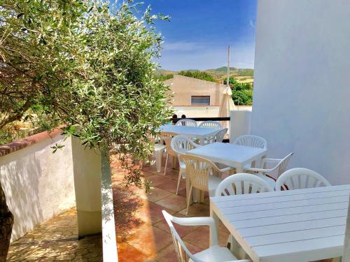 a group of tables and chairs on a patio at Apartment Luisa in Tergu