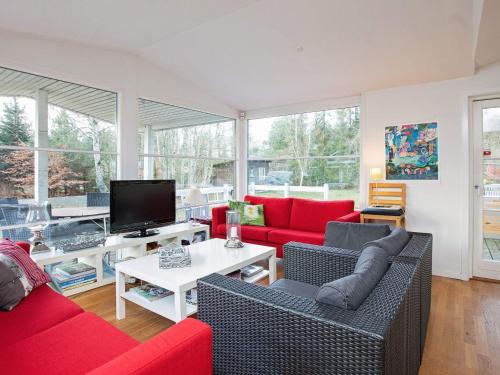 a living room with red couches and a tv at 6 person holiday home in G rlev in Gørlev