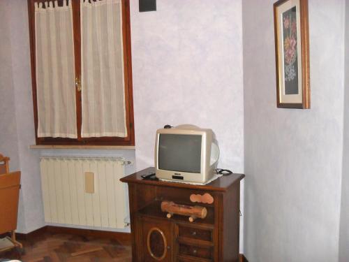 - une télévision installée au-dessus d'une table en bois dans l'établissement Affittacamere Casa Sofia, à Anghiari