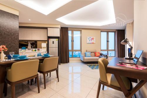 a kitchen and living room with a table and chairs at Dorsett Residences Sri Hartamas [5 Star Suites] in Kuala Lumpur