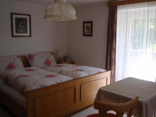 a bedroom with a bed and a table and a window at sonnberg in Ischgl