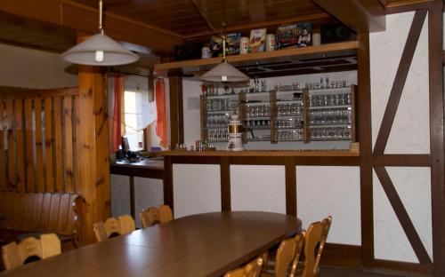 ein Esszimmer mit einem Tisch und einer Bar in der Unterkunft Gasthof Jägerheim in Birgland