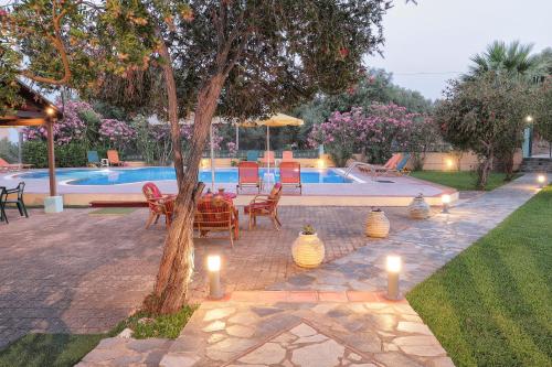 a patio with candles next to a swimming pool at Aria in Lakíthra