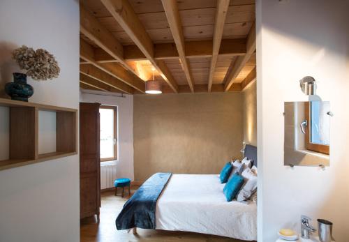 a bedroom with a bed with blue pillows at B&B Wood Cottage in Étretat