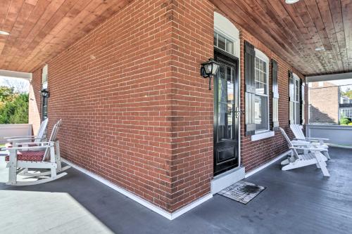 a brick wall with two chairs on a patio at Quaint Ligonier Family Home - 3 Miles to Idlewild! in Ligonier