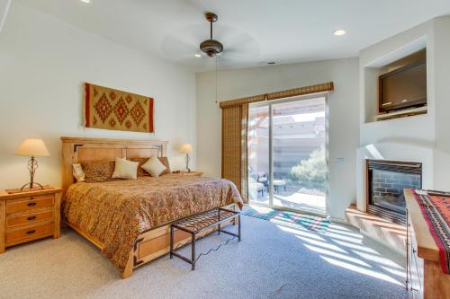 a bedroom with a bed and a fireplace and a window at Rim Village Two-Bedroom in Moab